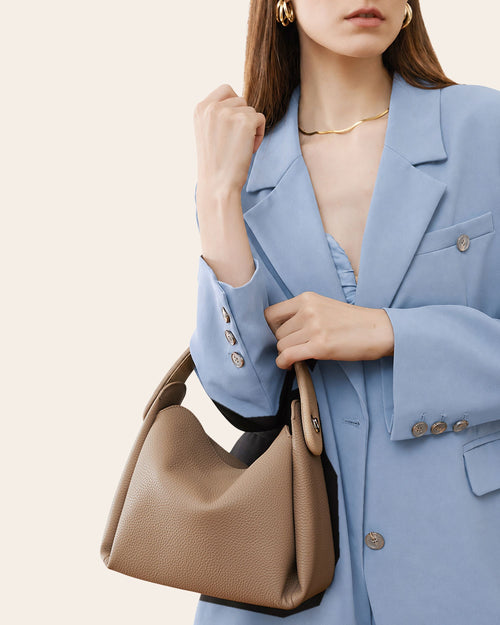 Embrace soft pebbled leather hobo bag in milk tea, with a dipped upper line and a rounded flap