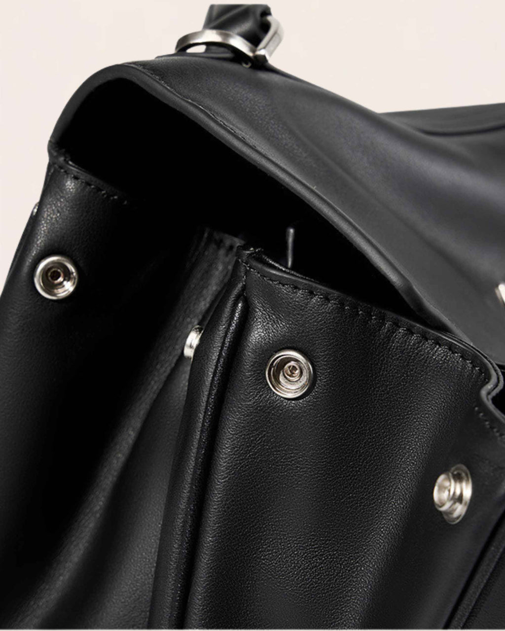 The bag seen from above with the flap open, showing the hidden press studs on the side panel